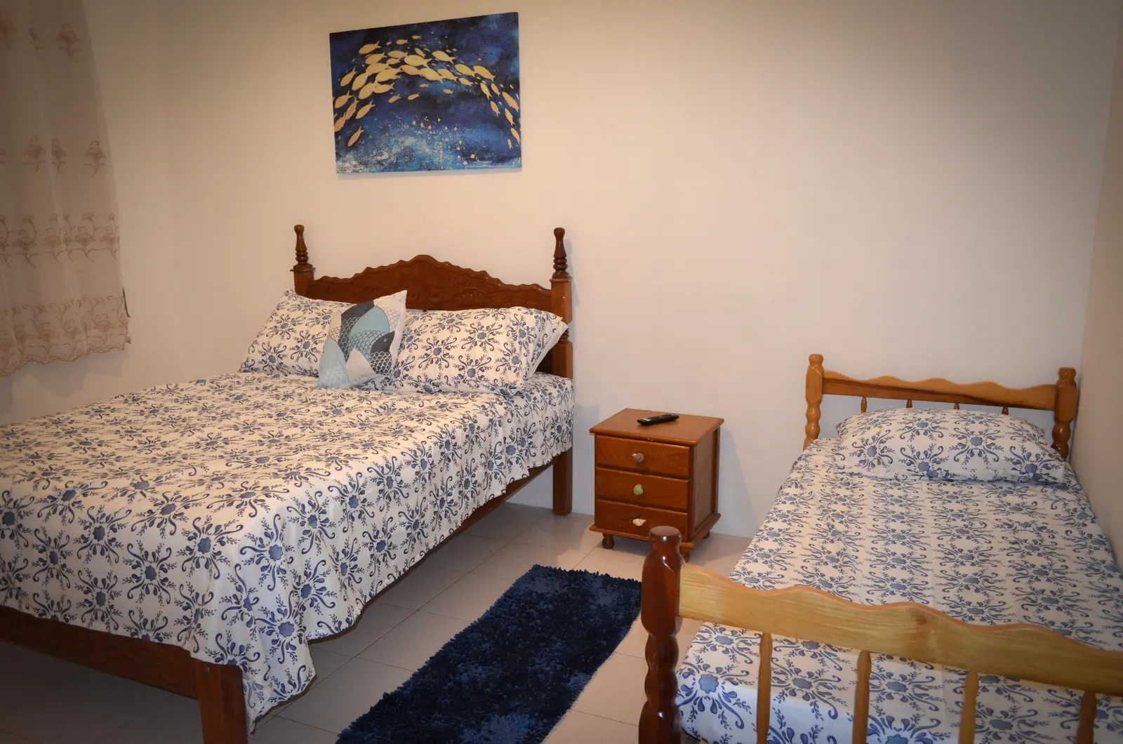 Quarto Azul com cama queen e cama de solteiro em madeira