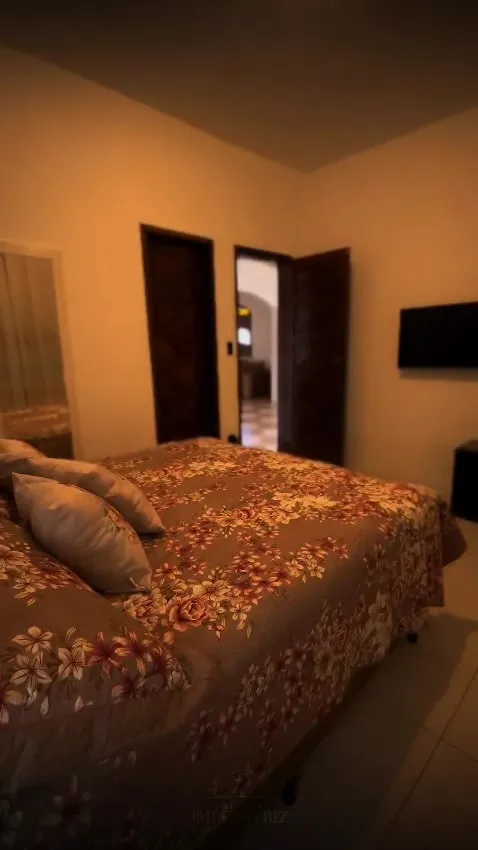 Suíte Orquídea vista da cama, com TV na parede